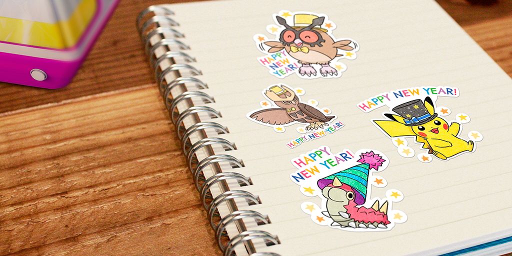 Vier verschiedene Pokemon Go New Year's 2023 Sticker auf einer Notizbuchseite