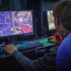 young man playing computer games in internet cafe